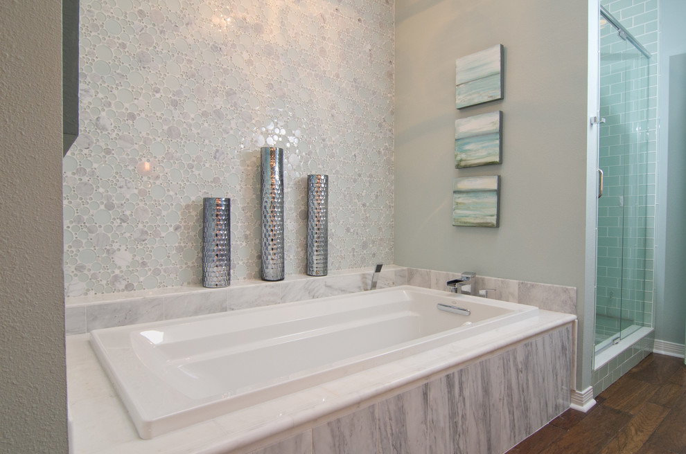Photo of a beach style bathroom in Miami with a vessel sink, white cabinets, engineered quartz benchtops, an alcove tub, an alcove shower, white tile, mosaic tile, blue walls and medium hardwood floors.