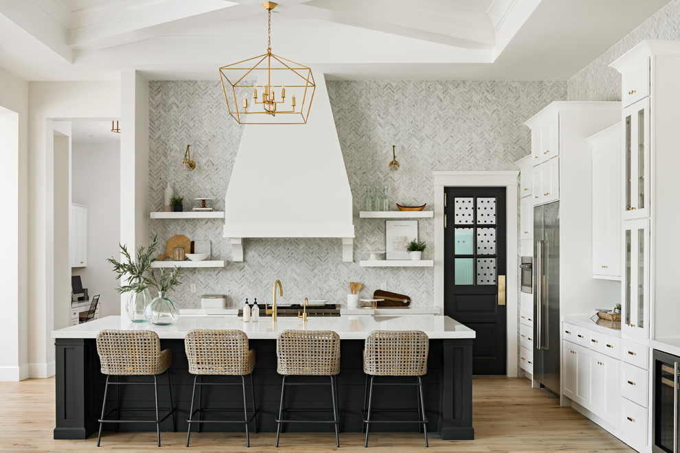 Open concept kitchen - huge transitional l-shaped light wood floor and beige floor open concept kitchen idea in Phoenix with an undermount sink, shaker cabinets, white cabinets, gray backsplash, stainless steel appliances, an island, quartz countertops and marble backsplash