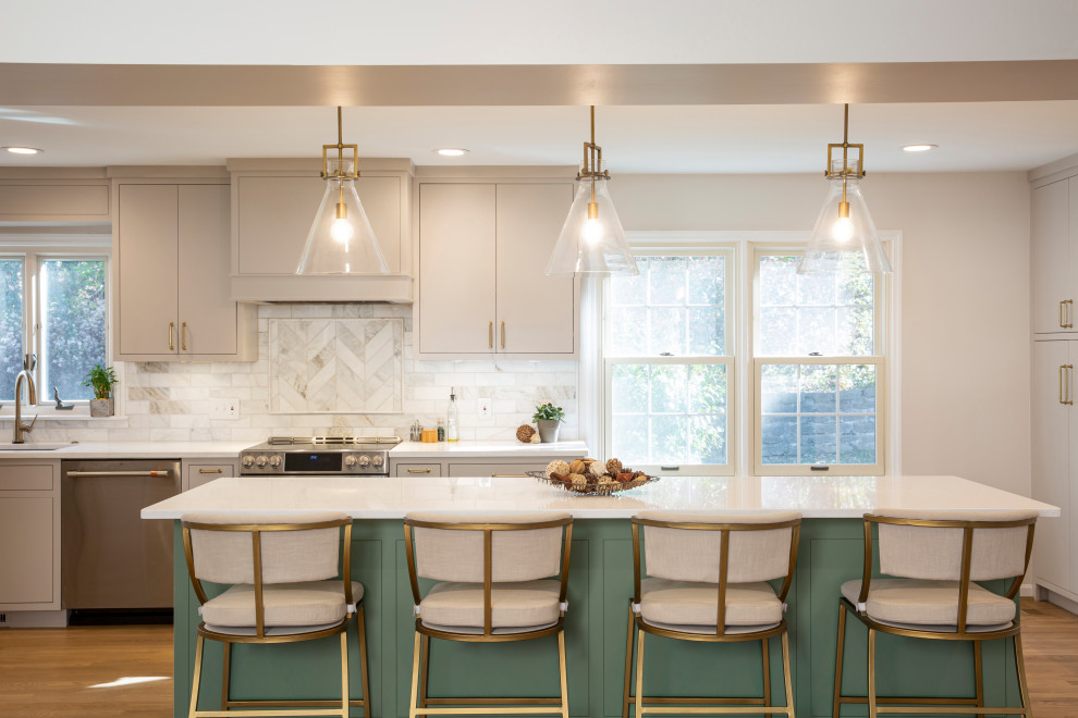 Example of a mid-sized transitional l-shaped medium tone wood floor eat-in kitchen design in Cincinnati with an undermount sink, green cabinets, quartz countertops, marble backsplash, stainless steel appliances, an island and white countertops
