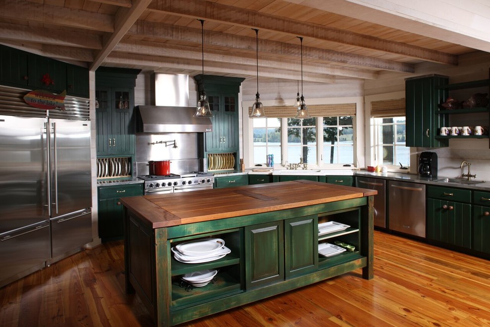 Large mountain style l-shaped medium tone wood floor open concept kitchen photo with a drop-in sink, green cabinets, white backsplash, stainless steel appliances, an island and stainless steel countertops