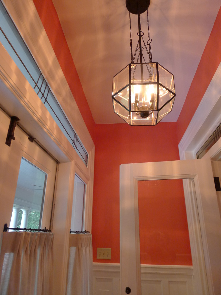 Photo of a large transitional vestibule in Baltimore with orange walls, a double front door and a white front door.