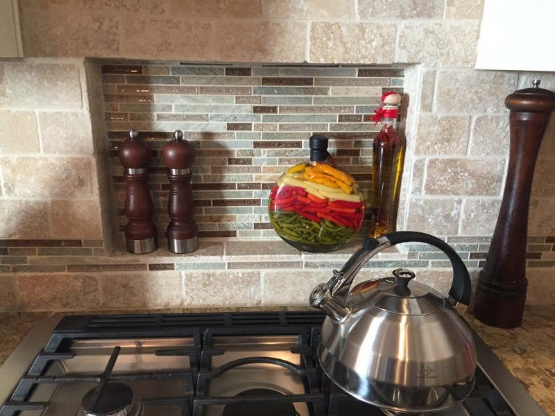 Inspiration for a mid-sized transitional u-shaped medium tone wood floor home design remodel with an undermount sink, flat-panel cabinets, dark wood cabinets, quartz countertops, beige backsplash, stone tile backsplash, stainless steel appliances and an island