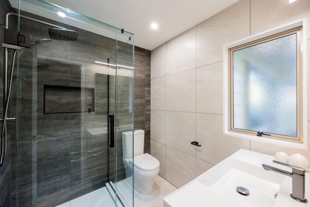 Small modern 3/4 bathroom in Auckland with light wood cabinets, a freestanding tub, an alcove shower, gray tile, ceramic tile, porcelain floors, an integrated sink, solid surface benchtops, white floor, a hinged shower door, white benchtops, a single vanity and a floating vanity.