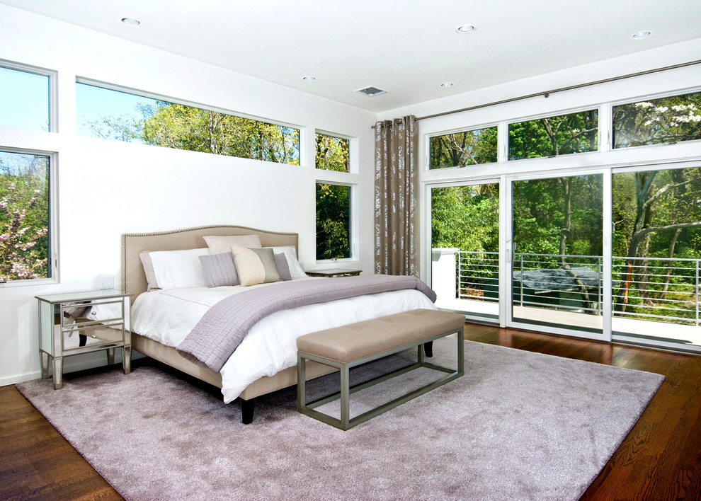 Photo of a contemporary bedroom in New York with white walls and dark hardwood floors.