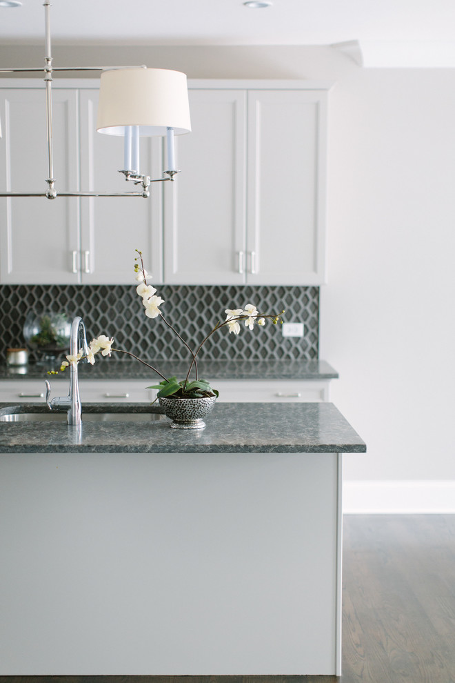Mid-sized transitional dark wood floor eat-in kitchen photo in Chicago with a single-bowl sink, shaker cabinets, white cabinets, granite countertops, black backsplash, glass tile backsplash, stainless steel appliances and an island