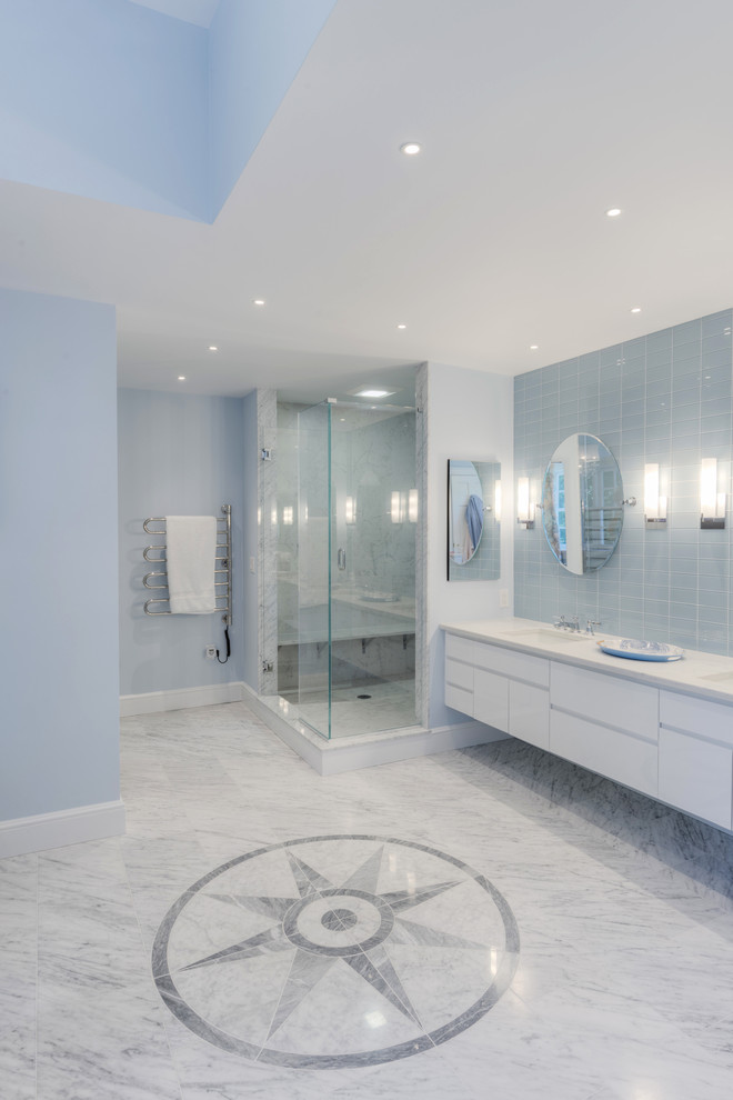 Photo of a large transitional master bathroom in Boston with flat-panel cabinets, white cabinets, a freestanding tub, an alcove shower, blue tile, glass tile, white walls, marble floors, an undermount sink and engineered quartz benchtops.