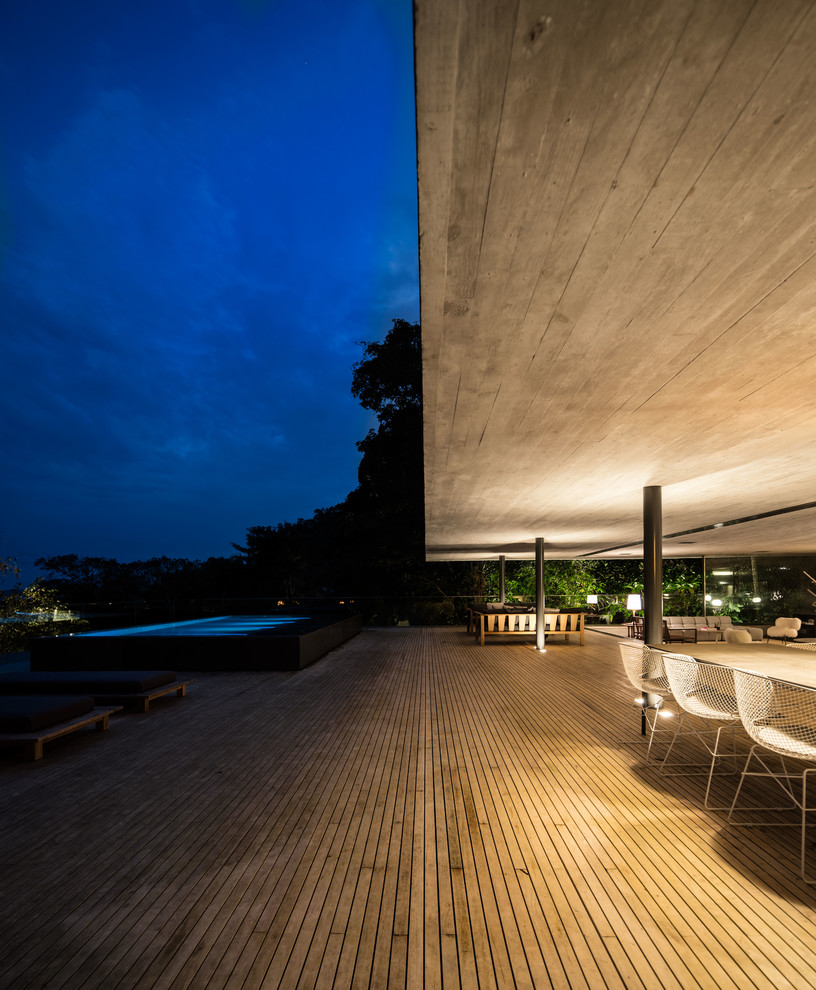 Huge minimalist balcony photo with a roof extension