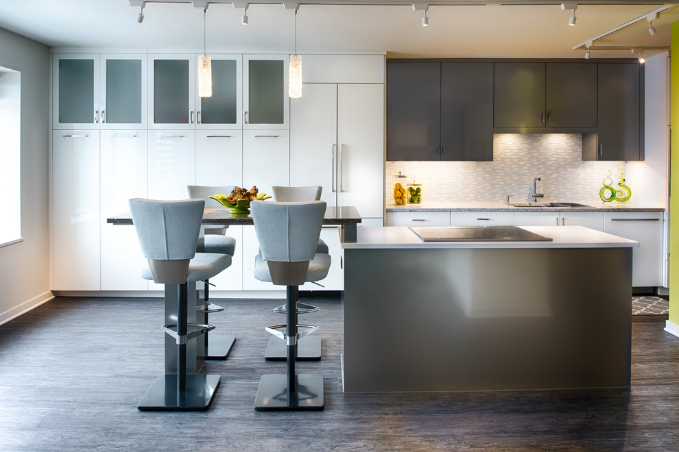 Photo of a small contemporary galley eat-in kitchen in Minneapolis with an undermount sink, flat-panel cabinets, white cabinets, quartz benchtops, multi-coloured splashback, glass tile splashback, panelled appliances, with island and dark hardwood floors.