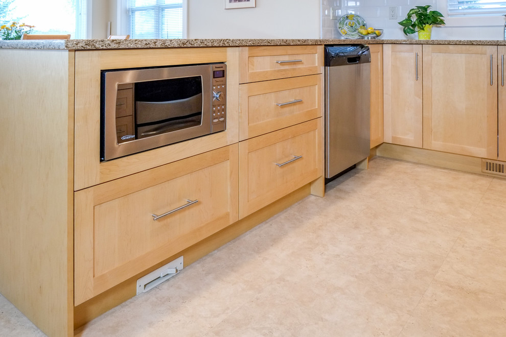 Mid-sized transitional u-shaped linoleum floor eat-in kitchen photo in Calgary with an undermount sink, shaker cabinets, medium tone wood cabinets, white backsplash, subway tile backsplash, stainless steel appliances and a peninsula