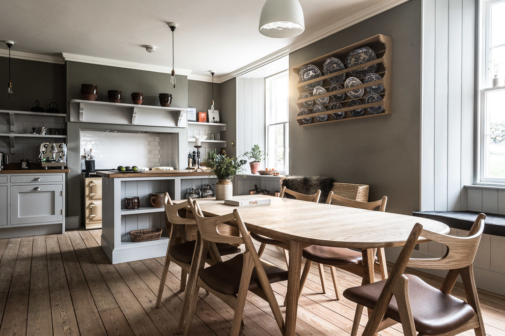 Photo of a country kitchen/dining combo in Edinburgh with grey walls and light hardwood floors.