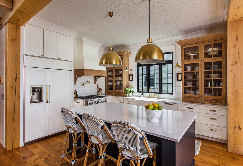 Photo of a large beach style l-shaped open plan kitchen in Detroit with raised-panel cabinets, white cabinets, quartz benchtops and with island.