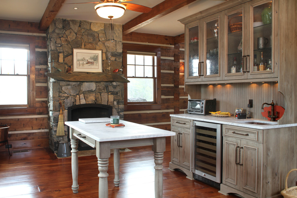 Photo of a mid-sized country single-wall eat-in kitchen in Other with distressed cabinets, marble benchtops, stainless steel appliances, medium hardwood floors, multiple islands, an undermount sink, glass-front cabinets and grey splashback.