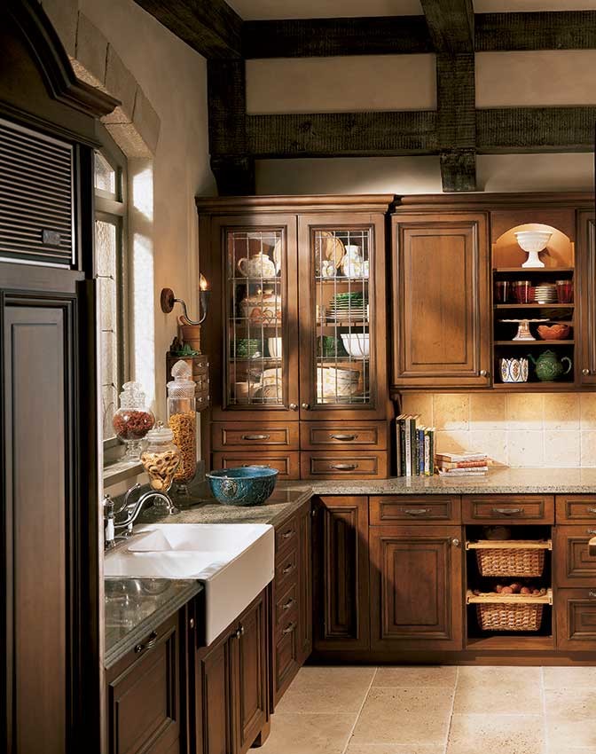 Enclosed kitchen - mid-sized rustic u-shaped enclosed kitchen idea in Jackson with a farmhouse sink, raised-panel cabinets, dark wood cabinets, granite countertops, beige backsplash, ceramic backsplash, stainless steel appliances and an island