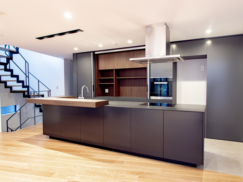 Inspiration for a contemporary galley open plan kitchen in Tokyo with flat-panel cabinets and an island.