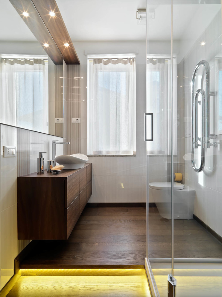 Photo of a contemporary bathroom in Milan with white walls, dark hardwood floors and a vessel sink.