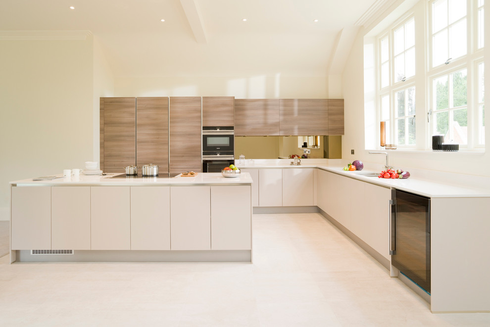 Inspiration for a contemporary open plan kitchen in London with an undermount sink, flat-panel cabinets, beige cabinets, quartzite benchtops, metallic splashback, glass sheet splashback, black appliances, ceramic floors and with island.