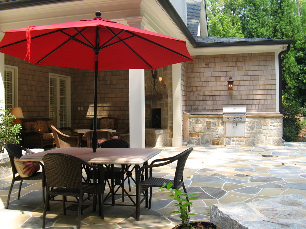 Photo of a mid-sized traditional patio in Atlanta with natural stone pavers and a roof extension.