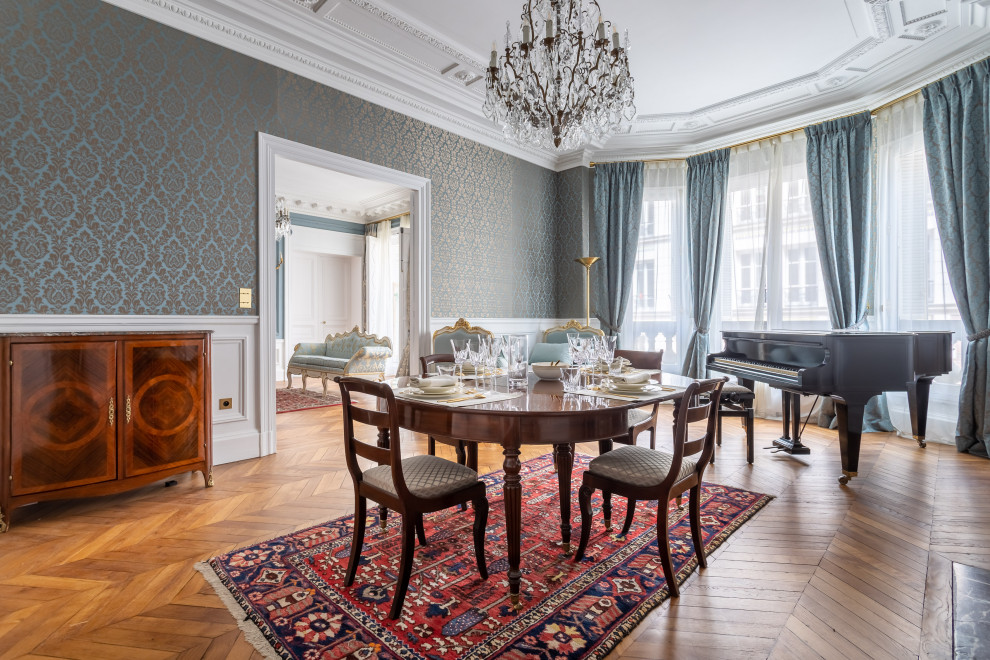 Large traditional separate dining room in Paris with blue walls, medium hardwood floors, a standard fireplace, brown floor and exposed beam.
