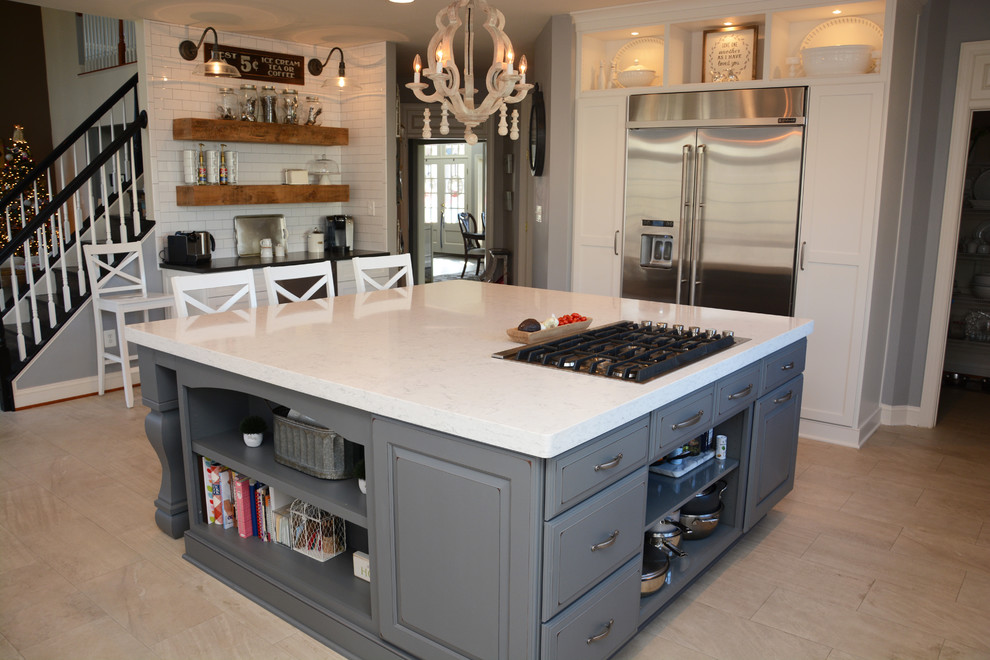 Example of a large transitional u-shaped eat-in kitchen design in DC Metro with a farmhouse sink, white cabinets, quartz countertops, white backsplash, ceramic backsplash, stainless steel appliances and an island