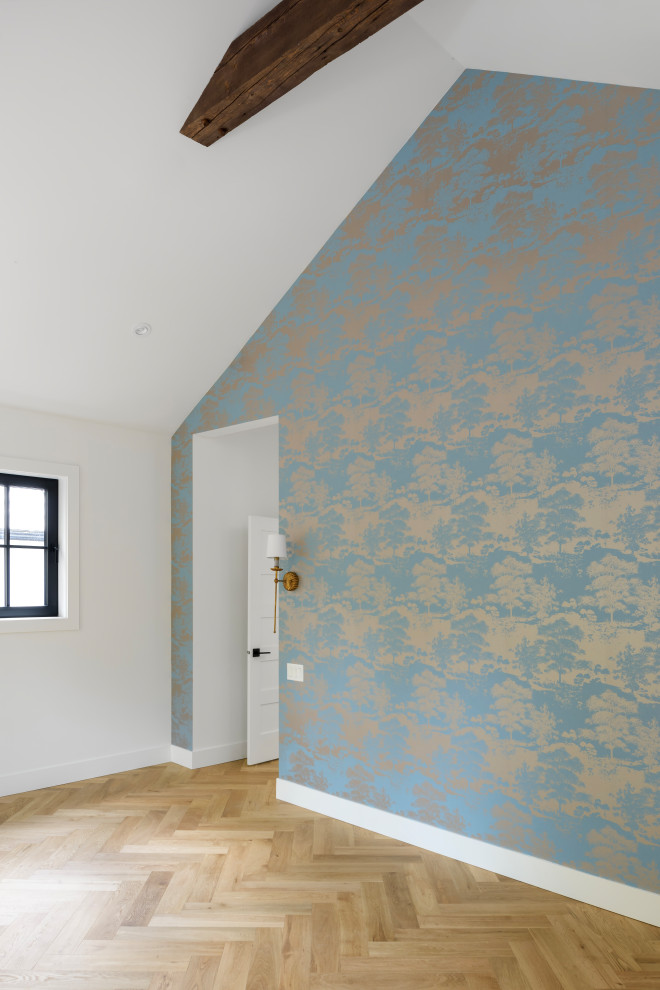 Modelo de dormitorio principal de estilo de casa de campo grande con paredes azules, suelo de madera en tonos medios, vigas vistas y papel pintado