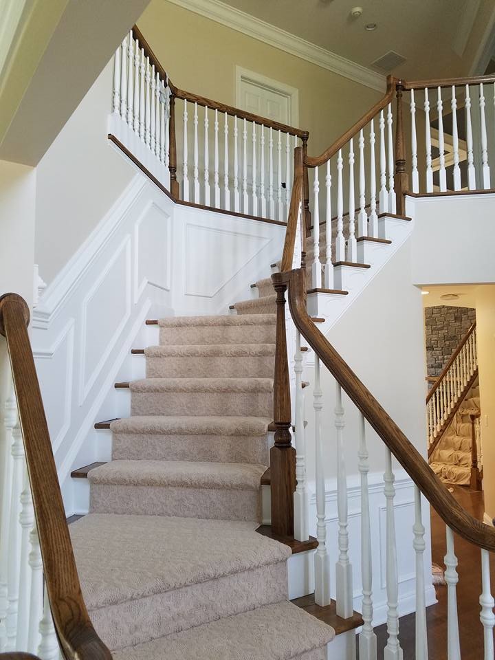 This is an example of a large traditional carpeted curved staircase in Boston with carpet risers.