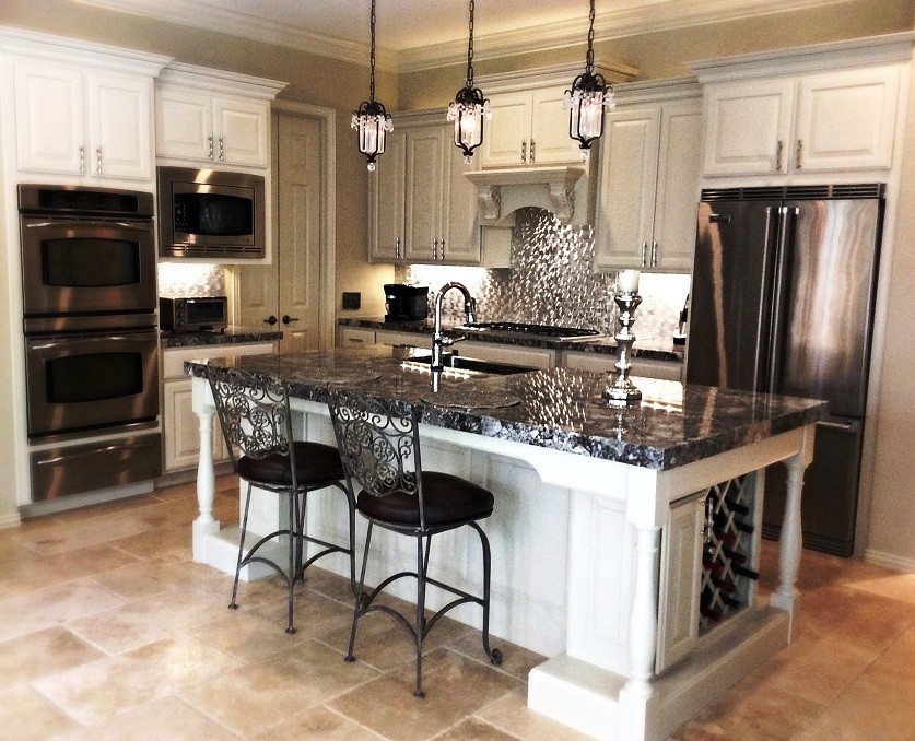Eat-in kitchen - mid-sized transitional l-shaped travertine floor eat-in kitchen idea in Houston with a farmhouse sink, raised-panel cabinets, white cabinets, granite countertops, metallic backsplash, metal backsplash, stainless steel appliances and an island