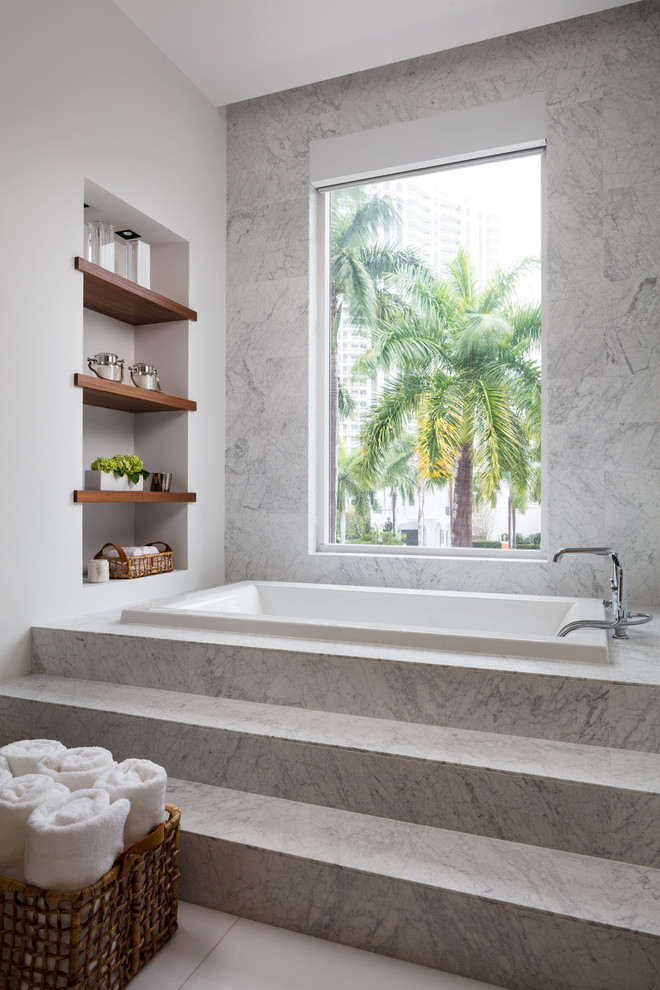 Large modern master bathroom in Miami with flat-panel cabinets, dark wood cabinets, a drop-in tub, a double shower, gray tile, white tile, stone slab, yellow walls, porcelain floors, an undermount sink, solid surface benchtops, white floor, a hinged shower door and white benchtops.