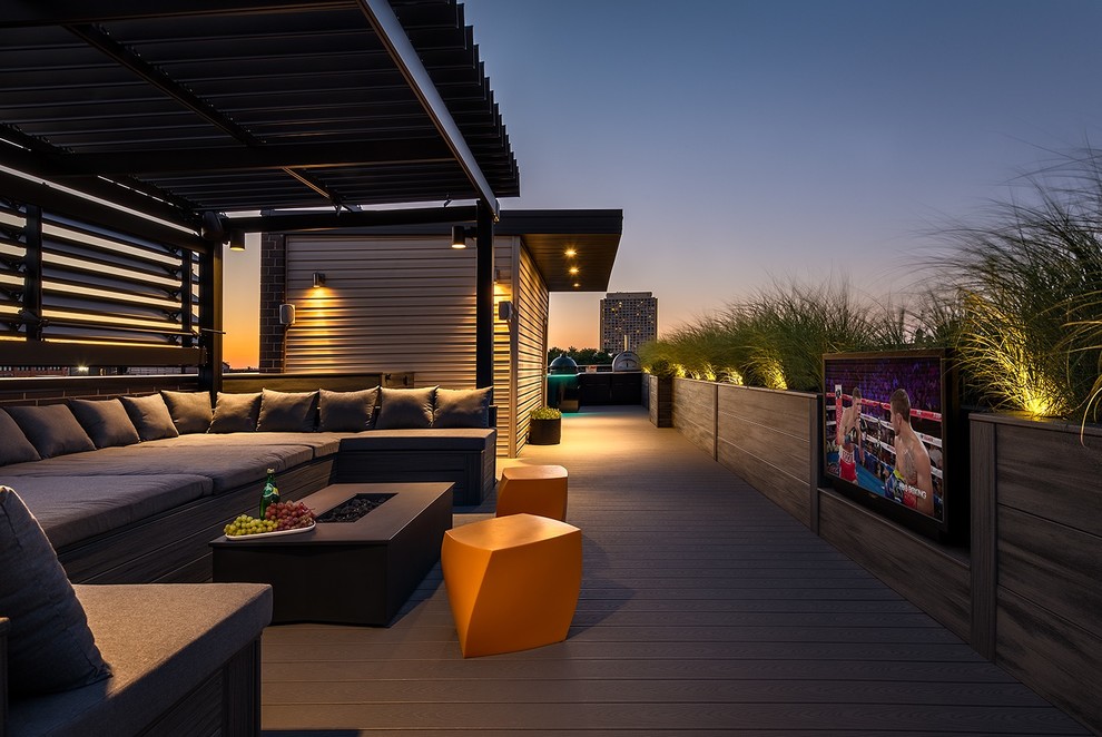 Photo of an expansive modern rooftop deck in Chicago with with fireplace and a pergola.