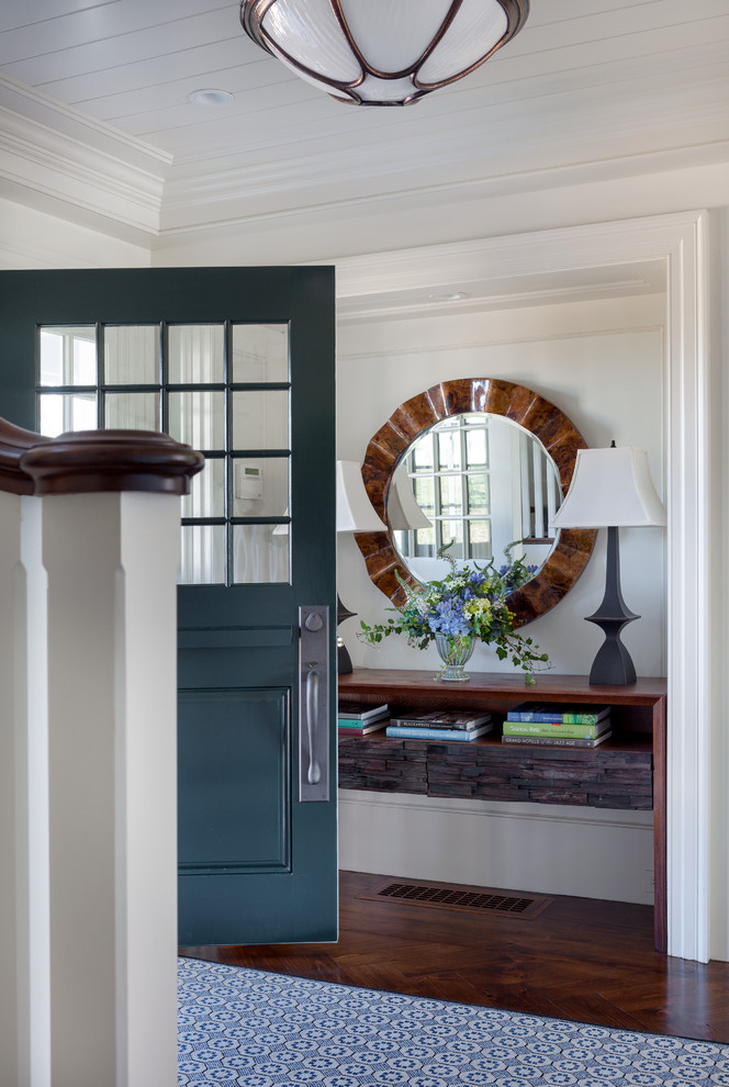 This is an example of a large beach style foyer in Boston with white walls, dark hardwood floors and a green front door.