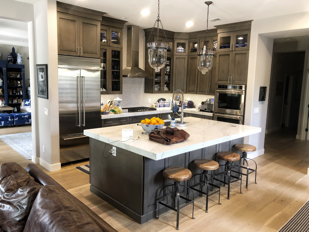 This is an example of a mid-sized transitional l-shaped open plan kitchen in Phoenix with an undermount sink, shaker cabinets, dark wood cabinets, quartz benchtops, stainless steel appliances, light hardwood floors, with island, beige floor and white benchtop.