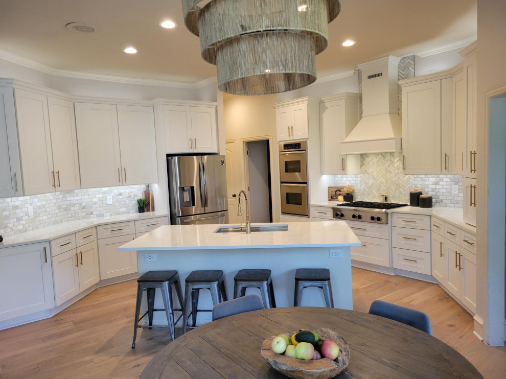 Large transitional u-shaped eat-in kitchen in Dallas with shaker cabinets, white cabinets, quartz benchtops, subway tile splashback, with island and white benchtop.