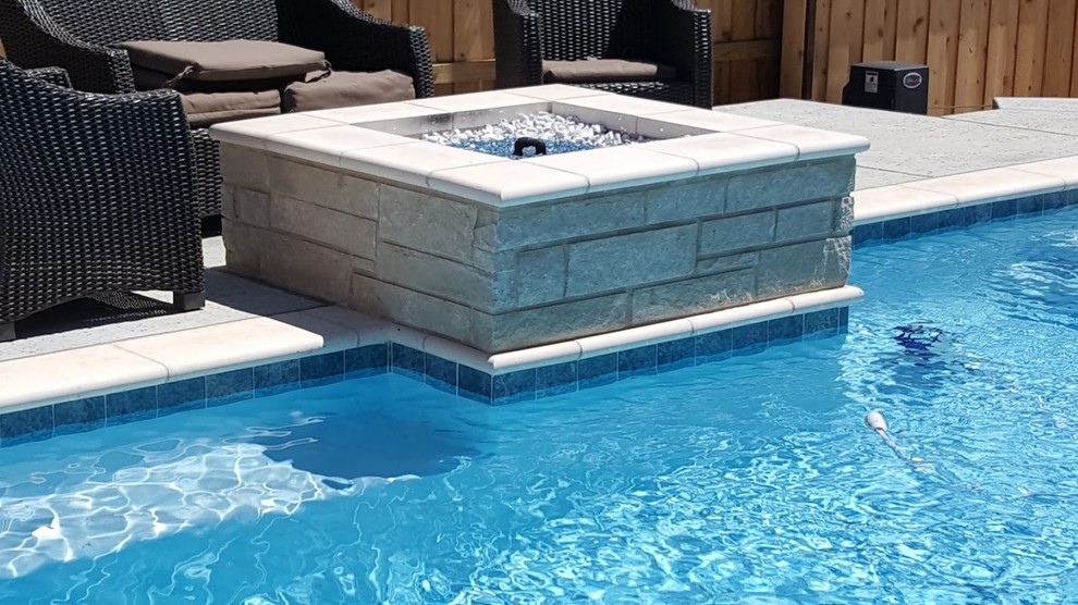 Mid-sized contemporary backyard custom-shaped natural pool in Dallas with a water feature and concrete pavers.