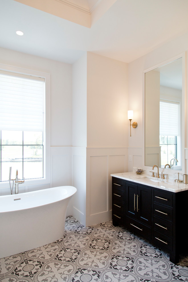 Design ideas for a large contemporary master bathroom in Kansas City with shaker cabinets, black cabinets, a freestanding tub, an alcove shower, white walls, ceramic floors, an undermount sink, marble benchtops, grey floor, a hinged shower door and white benchtops.