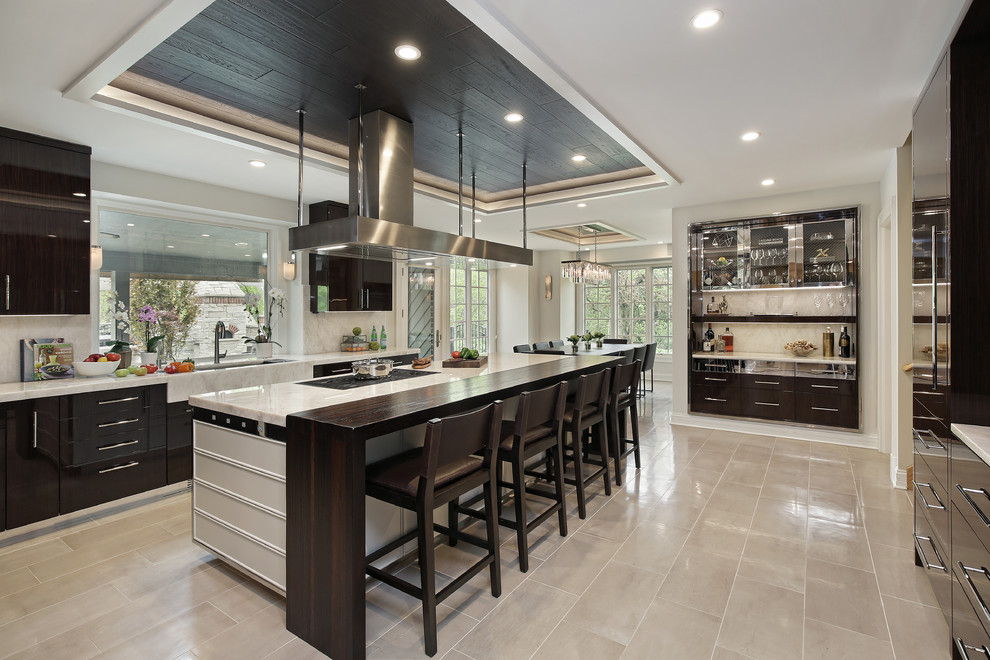 Inspiration for an expansive modern u-shaped open plan kitchen in Chicago with a triple-bowl sink, flat-panel cabinets, dark wood cabinets, quartzite benchtops, white splashback, stone slab splashback, stainless steel appliances, with island, white benchtop, porcelain floors and beige floor.