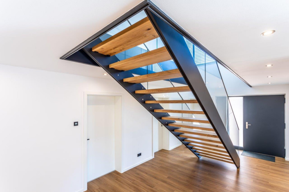 Inspiration pour un escalier sans contremarche design avec des marches en bois et un garde-corps en verre.