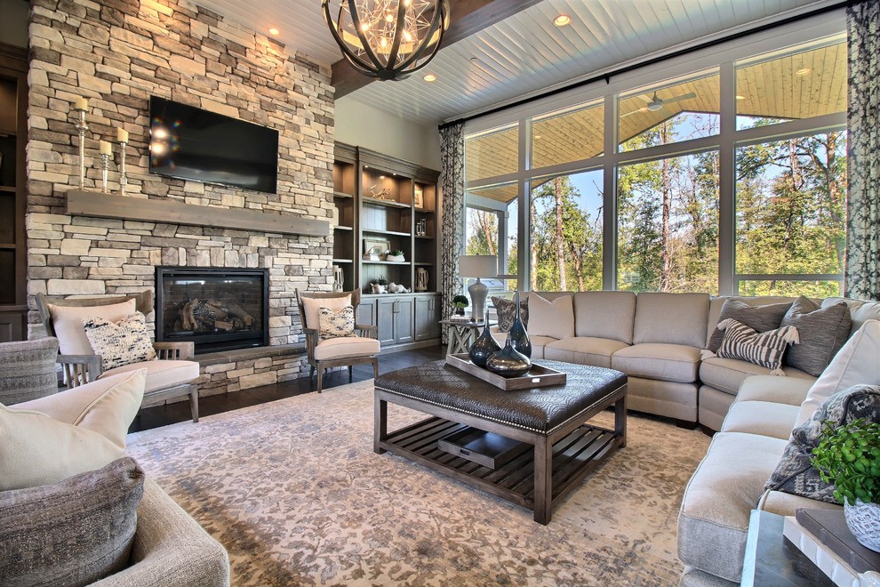Design ideas for an expansive arts and crafts open concept family room in Portland with beige walls, dark hardwood floors, a standard fireplace, a stone fireplace surround, brown floor and a wall-mounted tv.