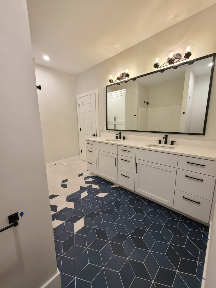 Large minimalist kids' ceramic tile, blue floor and double-sink bathroom photo in Other with recessed-panel cabinets, white cabinets, a two-piece toilet, white walls, an undermount sink, solid surface countertops, white countertops and a freestanding vanity