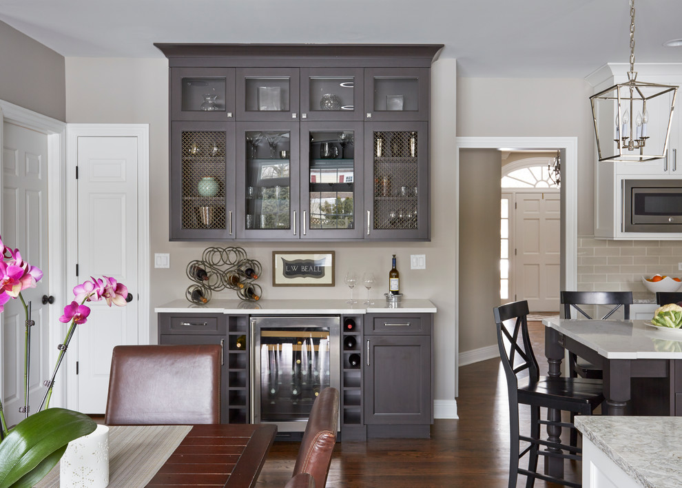 Large transitional u-shaped medium tone wood floor open concept kitchen photo in Chicago with a double-bowl sink, flat-panel cabinets, white cabinets, quartz countertops, beige backsplash, subway tile backsplash, stainless steel appliances and an island