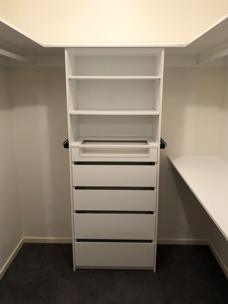 Design ideas for a mid-sized modern women's walk-in wardrobe in Newcastle - Maitland with open cabinets, white cabinets, carpet and black floor.