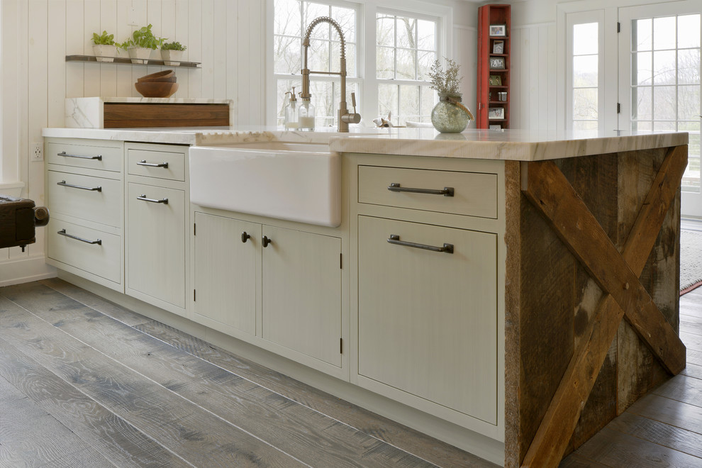 Inspiration for a large traditional u-shaped eat-in kitchen in New York with a farmhouse sink, flat-panel cabinets, green cabinets, marble benchtops, white splashback, panelled appliances, medium hardwood floors, a peninsula, brown floor and multi-coloured benchtop.