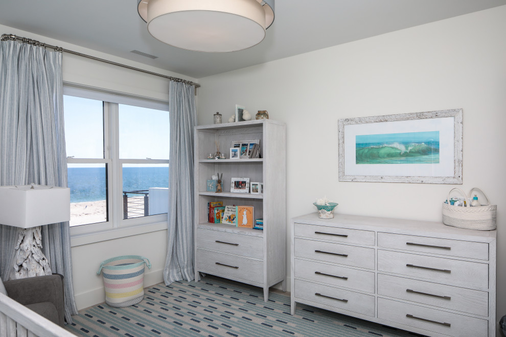 Esempio di una cameretta per neonati costiera di medie dimensioni con pareti beige e moquette