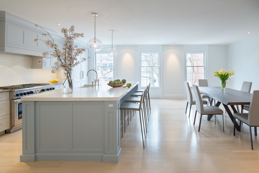 Large transitional single-wall laminate floor and beige floor eat-in kitchen photo in DC Metro with a farmhouse sink, flat-panel cabinets, blue cabinets, quartz countertops, white backsplash, mosaic tile backsplash, stainless steel appliances, an island and gray countertops