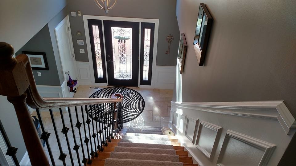 Large transitional travertine floor and beige floor front door photo in Chicago with brown walls and a glass front door