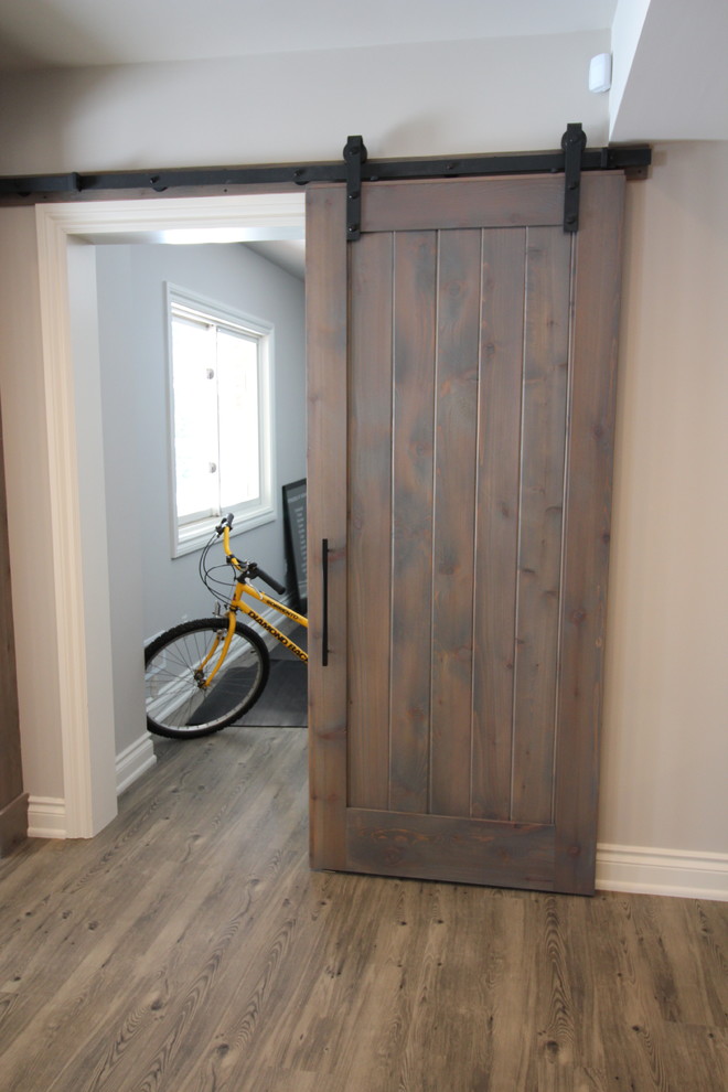 Example of a large transitional walk-out vinyl floor basement design in Detroit with gray walls