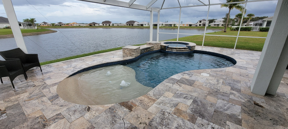 Esempio di una piscina naturale tropicale dietro casa con pavimentazioni in pietra naturale