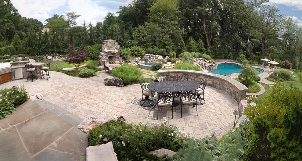 Photo of a mid-sized country backyard full sun garden in DC Metro with natural stone pavers and a fire feature.