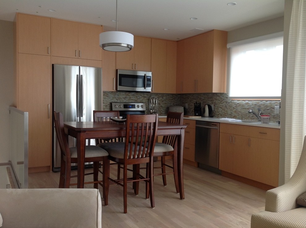 Enclosed kitchen - mid-sized transitional galley light wood floor enclosed kitchen idea in Vancouver with a drop-in sink, recessed-panel cabinets, dark wood cabinets, marble countertops, green backsplash, ceramic backsplash and stainless steel appliances