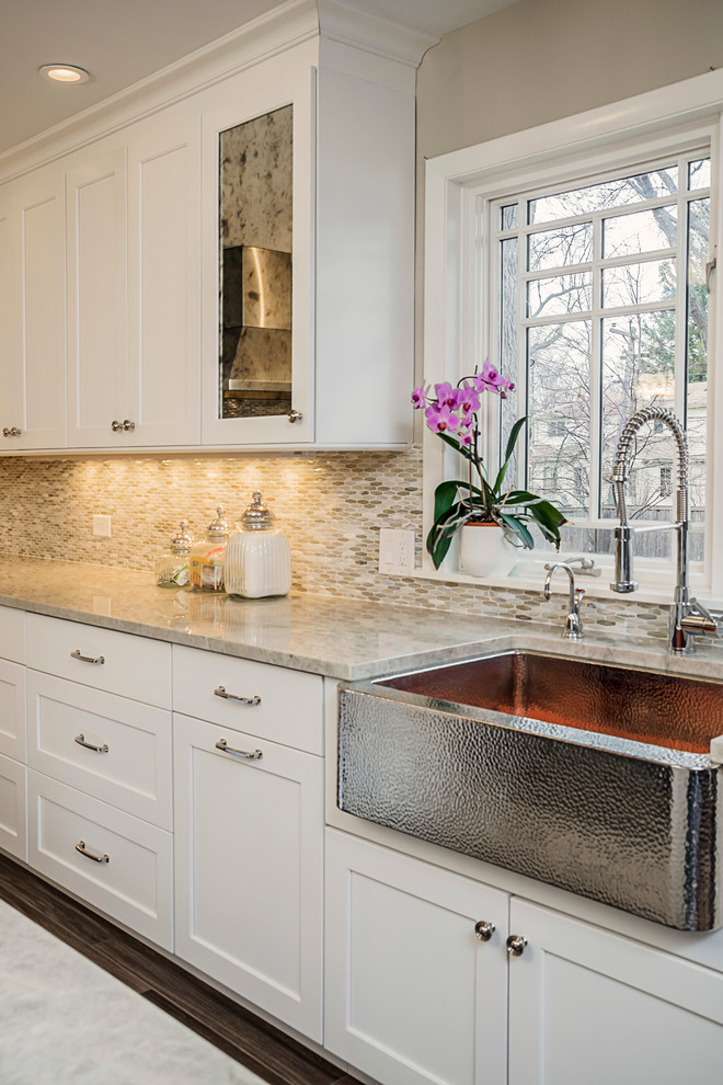 Eat-in kitchen - large transitional galley porcelain tile eat-in kitchen idea in Chicago with a farmhouse sink, shaker cabinets, white cabinets, quartzite countertops, multicolored backsplash, glass sheet backsplash, stainless steel appliances and an island
