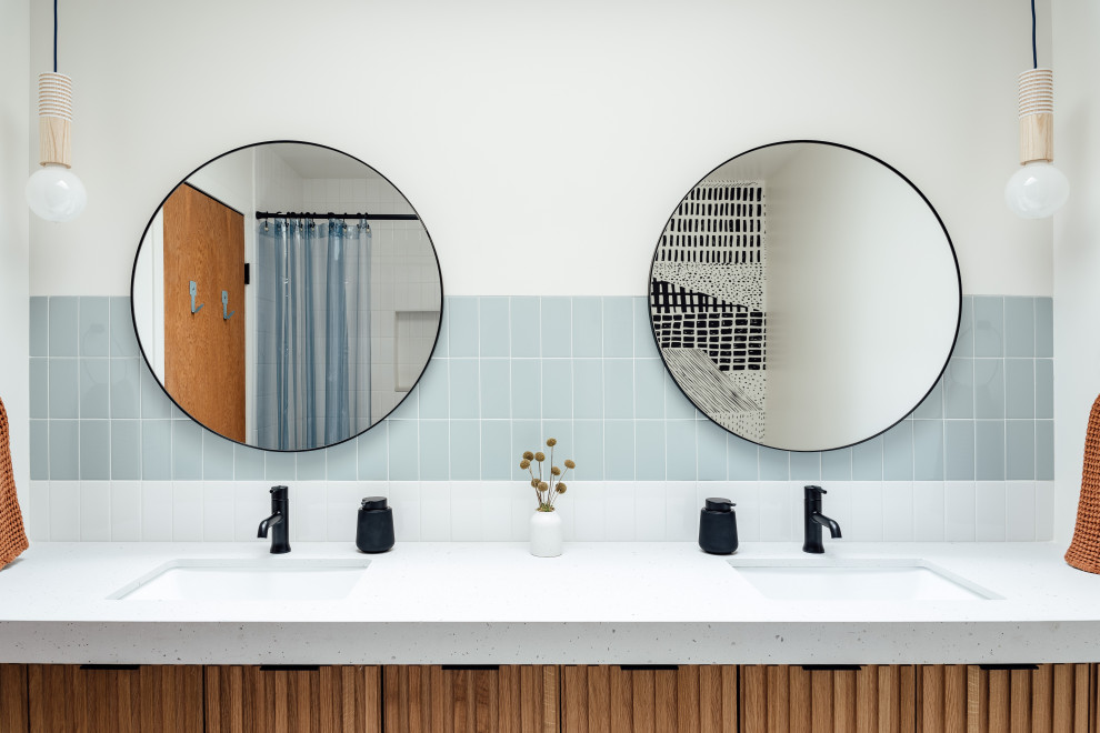 This is an example of a bathroom in Salt Lake City with medium wood cabinets, a shower/bathtub combo, blue tile, terrazzo floors, an undermount sink, green floor, a shower curtain, grey benchtops, a double vanity and a floating vanity.