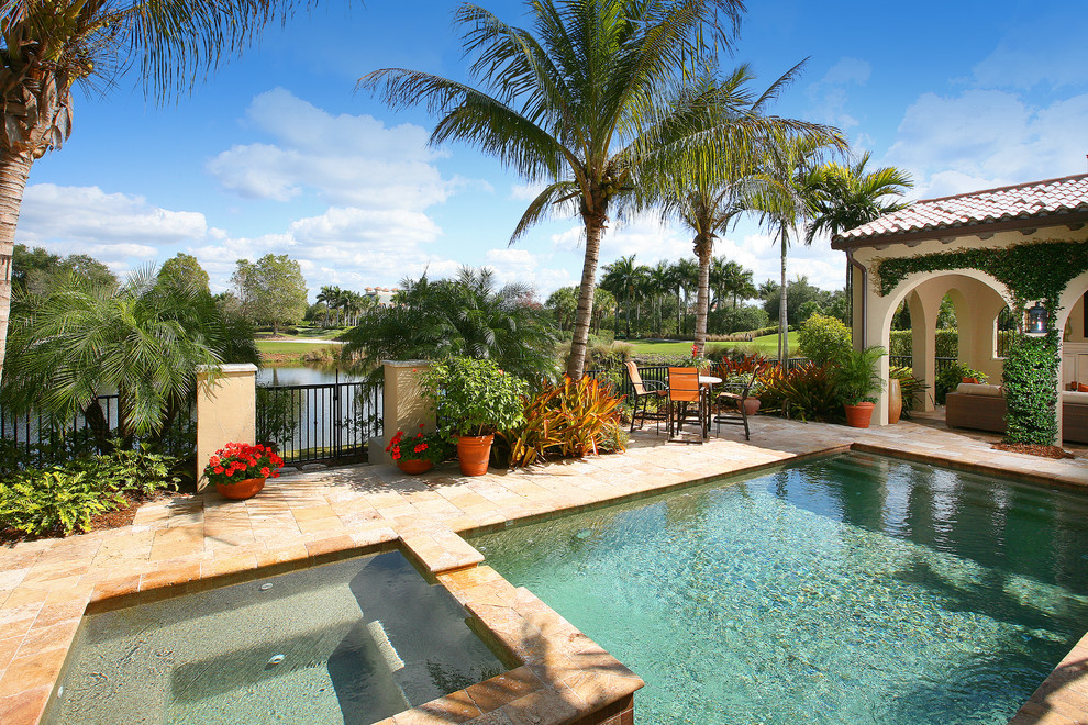 Design ideas for a mediterranean pool in Miami with natural stone pavers.